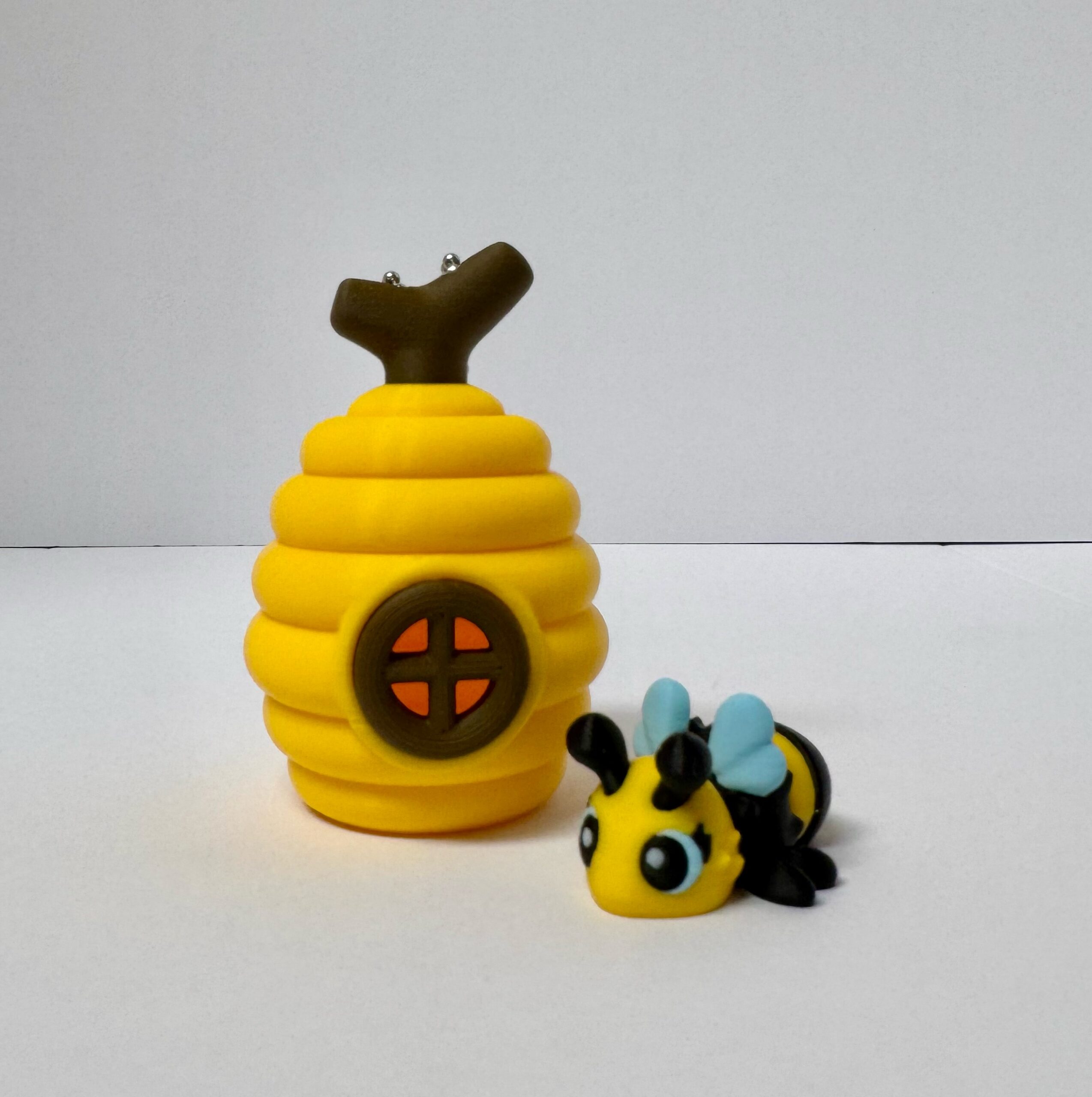 A little bee companion beside its yellow hive.