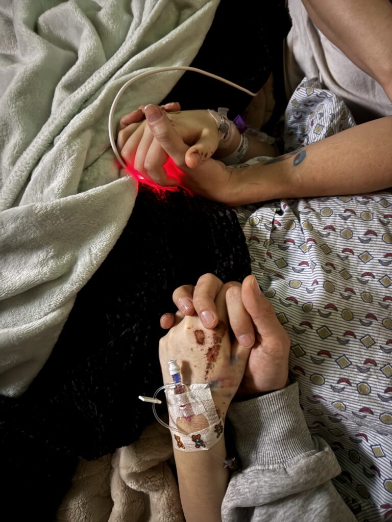 Brooklyn holding hands with family during her hospital stay.